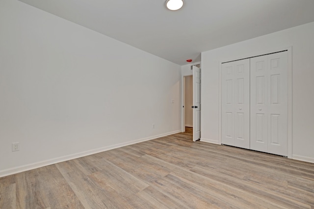 unfurnished bedroom featuring a closet and light wood-type flooring