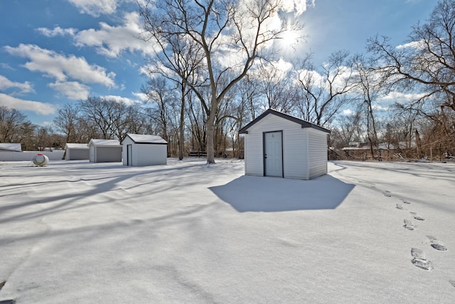 yard covered in snow featuring a shed