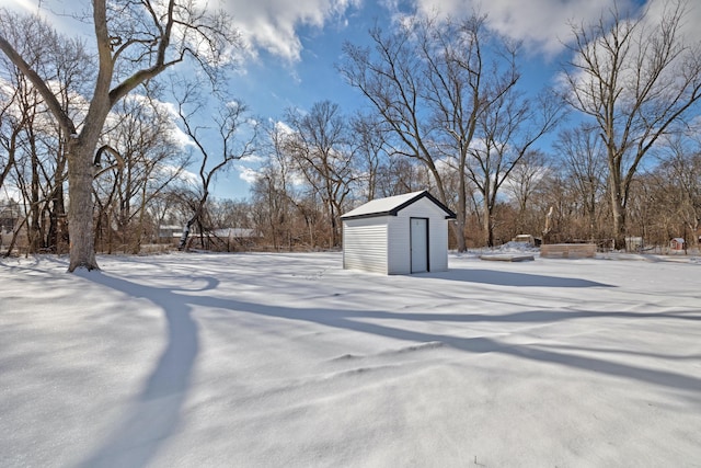 yard layered in snow featuring a shed