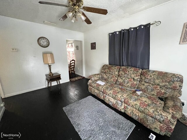 living room with ceiling fan, dark hardwood / wood-style flooring, and a textured ceiling