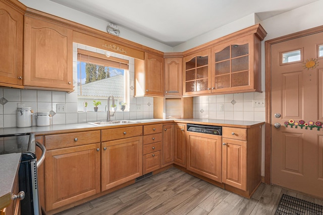 kitchen with tasteful backsplash, stainless steel electric range oven, sink, and light hardwood / wood-style flooring