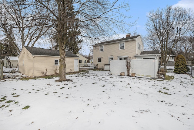 view of snow covered rear of property