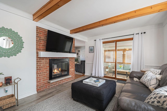 living room with dark hardwood / wood-style flooring, a brick fireplace, and beam ceiling