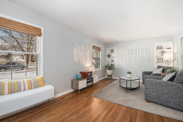 living room featuring dark wood-type flooring and built in features