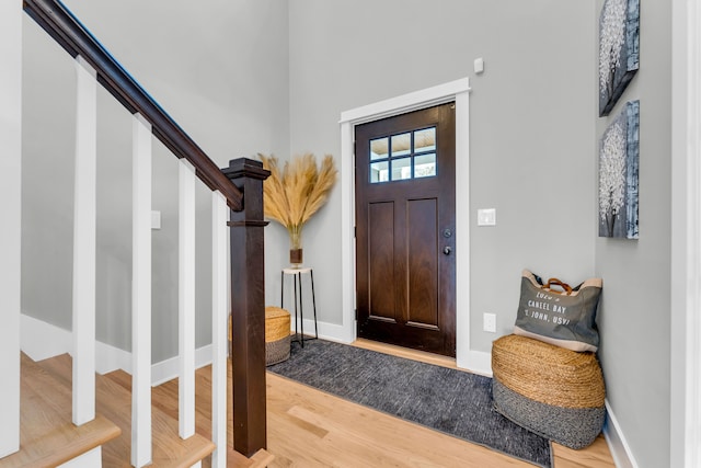 entryway featuring stairway, baseboards, and wood finished floors