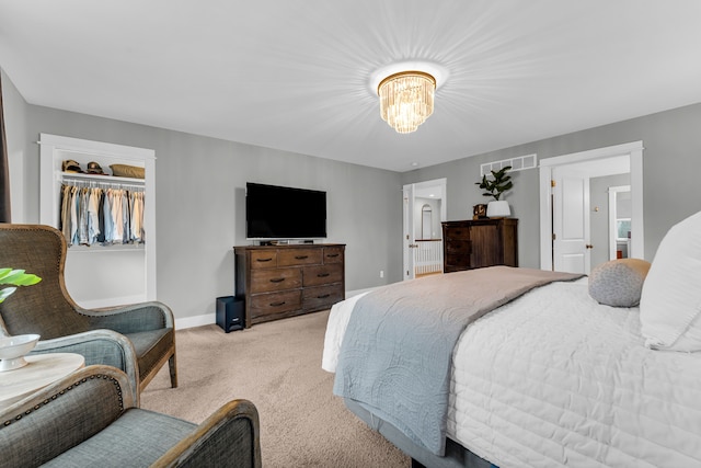 bedroom with a notable chandelier, visible vents, light carpet, ensuite bath, and baseboards