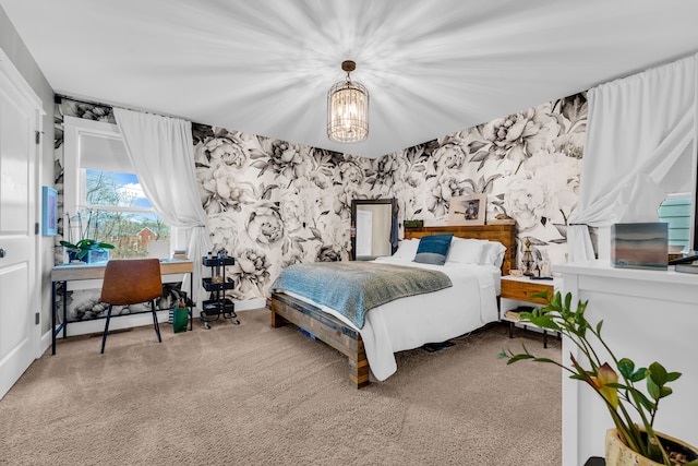 carpeted bedroom with wallpapered walls and an inviting chandelier