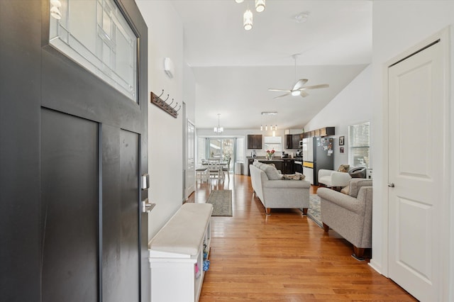 entryway featuring ceiling fan, high vaulted ceiling, and light wood-type flooring