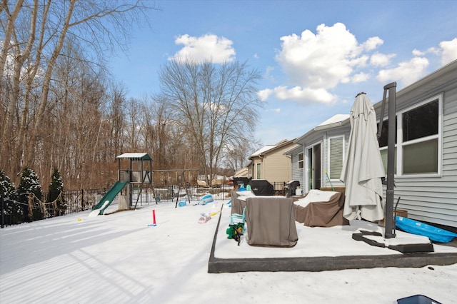 yard layered in snow with a playground