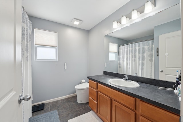 bathroom with vanity, toilet, and a wealth of natural light