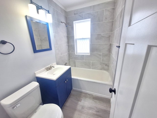 full bathroom featuring tiled shower / bath combo, vanity, wood-type flooring, and toilet