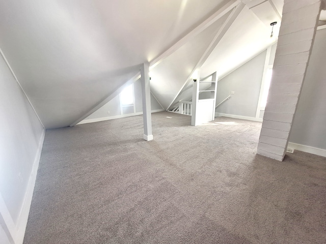 bonus room with vaulted ceiling, carpet flooring, and built in shelves