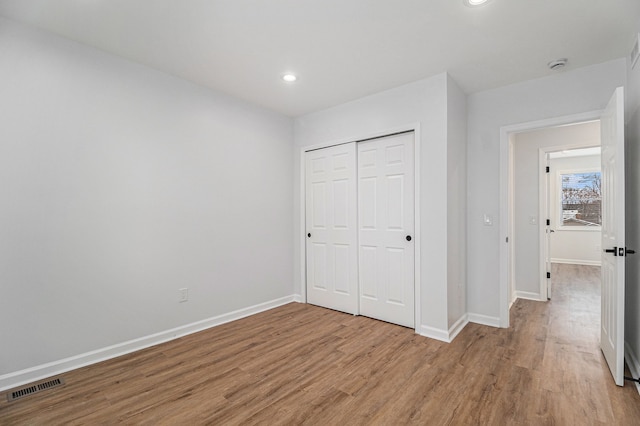 unfurnished bedroom featuring visible vents, baseboards, and light wood-type flooring