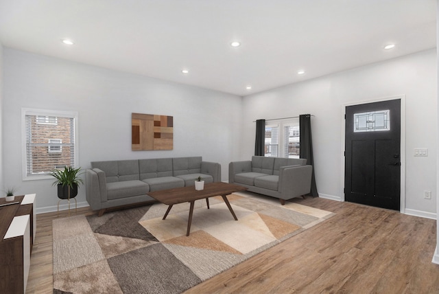 living room with light wood-type flooring, recessed lighting, and baseboards