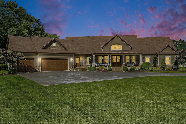 view of front of house with stone siding, concrete driveway, a front yard, a porch, and an attached garage