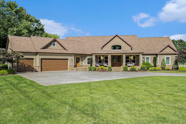 craftsman-style house featuring covered porch, an attached garage, stone siding, concrete driveway, and a front yard