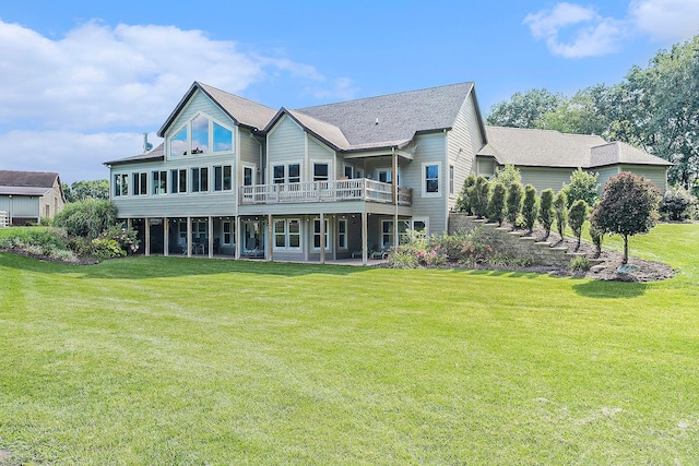 rear view of property with a wooden deck and a lawn