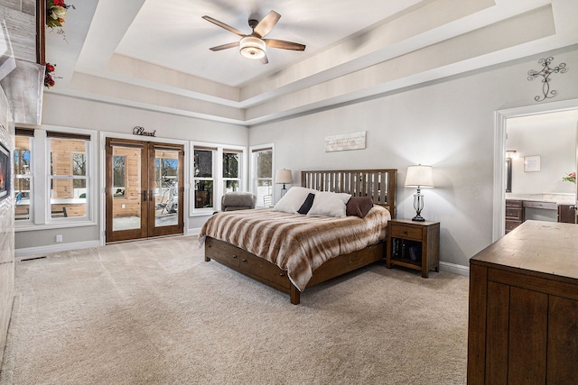 bedroom featuring access to exterior, baseboards, french doors, a tray ceiling, and light colored carpet