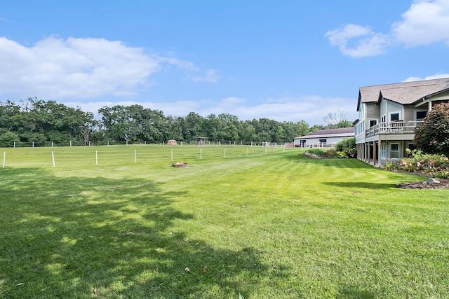 view of yard with fence and a rural view