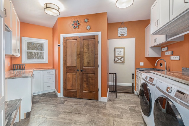 laundry room featuring baseboards, separate washer and dryer, and cabinet space