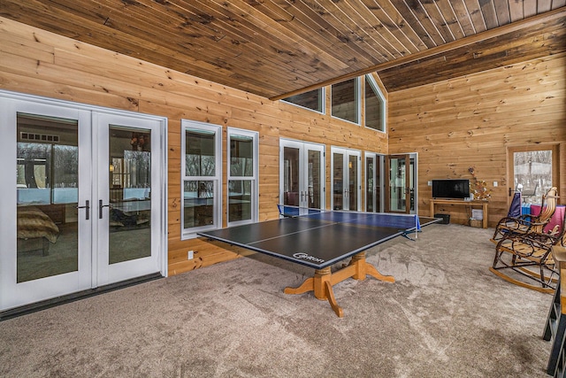 game room with carpet flooring, french doors, and wooden walls