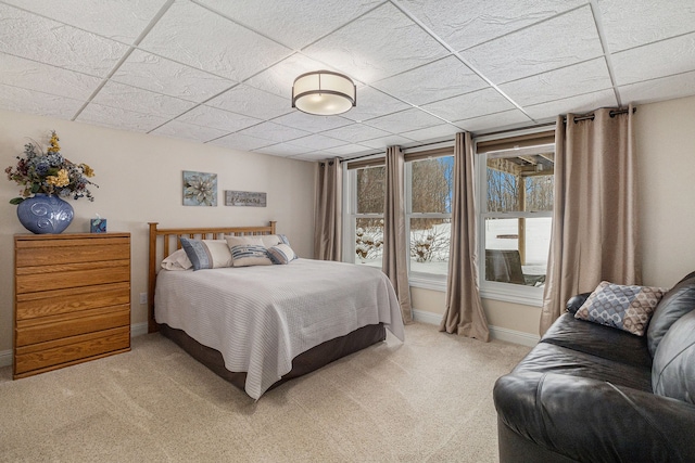 carpeted bedroom with baseboards and a drop ceiling