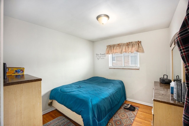 bedroom featuring baseboards and wood finished floors