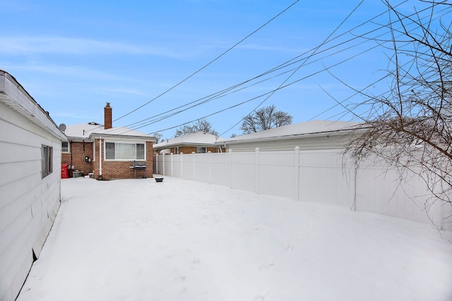 yard layered in snow with fence