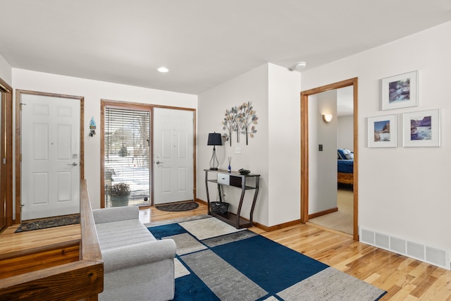 foyer entrance with light wood-style flooring, recessed lighting, visible vents, and baseboards