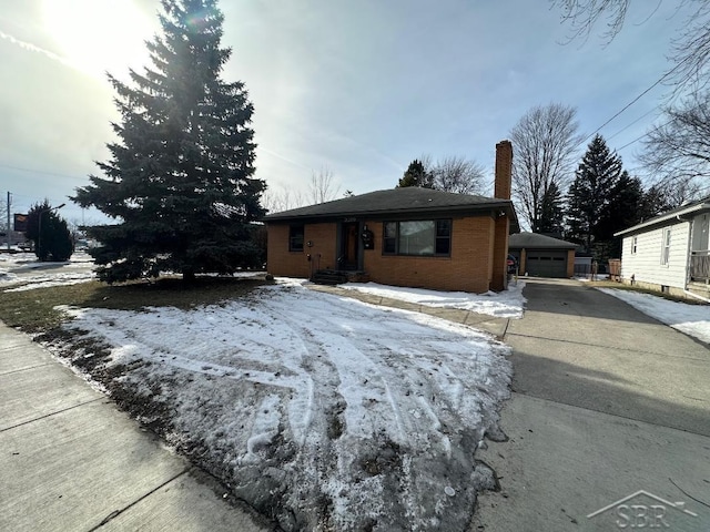 ranch-style house with a garage and an outbuilding