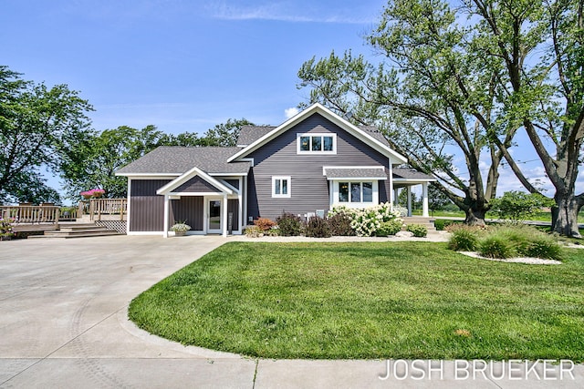 view of front facade featuring a wooden deck and a front lawn