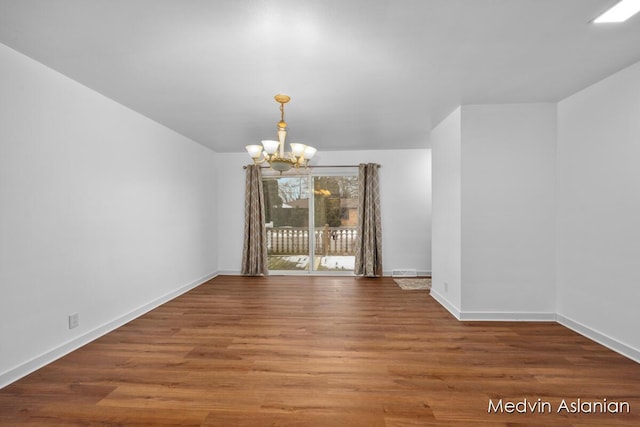 unfurnished dining area featuring hardwood / wood-style flooring and an inviting chandelier