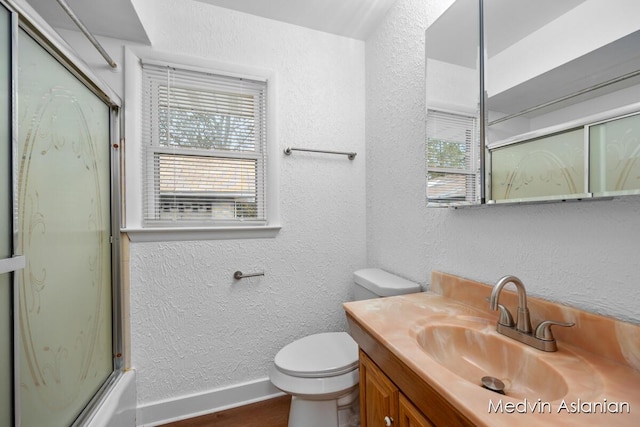 full bathroom with vanity, combined bath / shower with glass door, and toilet