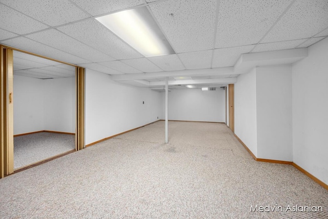 basement featuring carpet floors and a drop ceiling