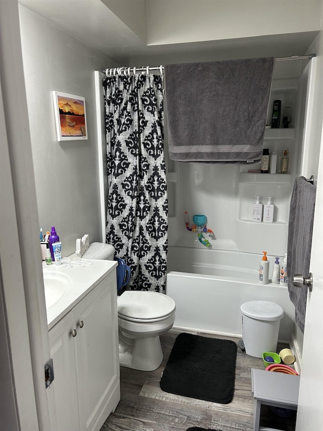 full bathroom featuring vanity, wood-type flooring, toilet, and shower / bath combo with shower curtain