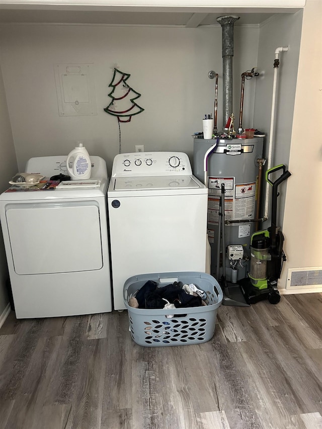 laundry room featuring gas water heater, hardwood / wood-style floors, and washing machine and dryer