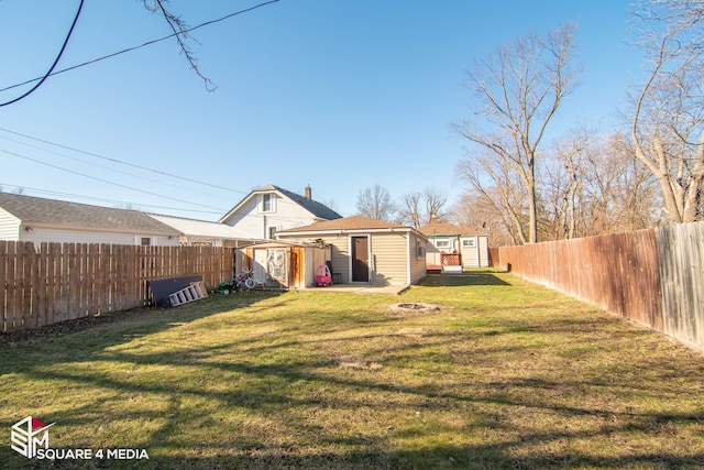 rear view of house featuring an outbuilding, a yard, an outdoor fire pit, a shed, and a fenced backyard