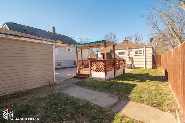 view of yard with a fenced backyard, an outdoor structure, and a wooden deck