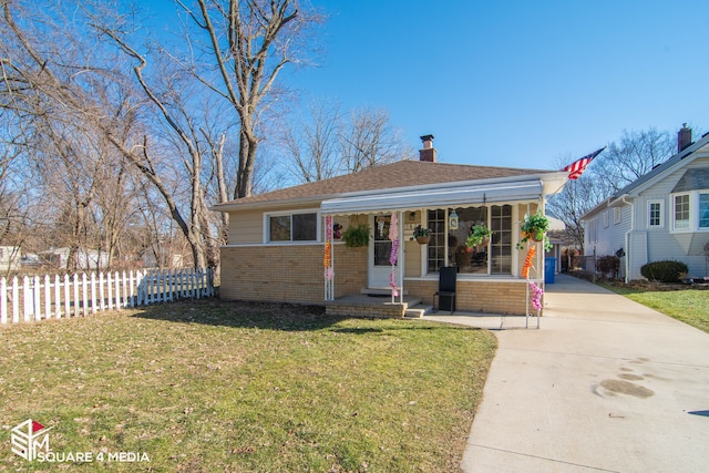 bungalow featuring driveway, a porch, fence, a front lawn, and brick siding