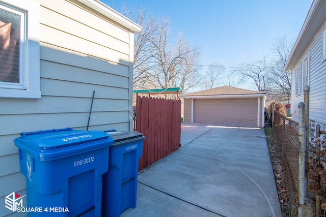 view of side of property featuring a garage, an outbuilding, and fence