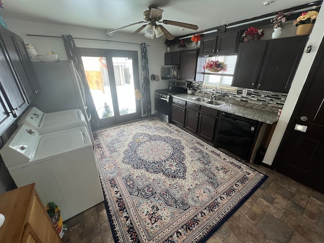 kitchen with a sink, washer and dryer, appliances with stainless steel finishes, backsplash, and stone finish flooring