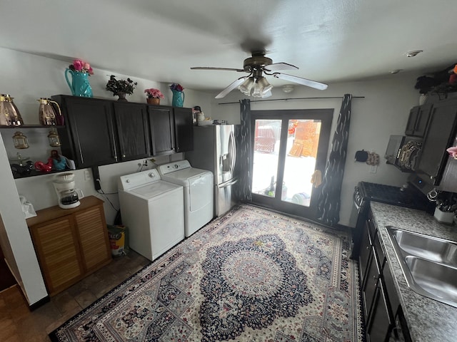 interior space featuring a ceiling fan, stainless steel fridge with ice dispenser, light stone countertops, washing machine and dryer, and a sink