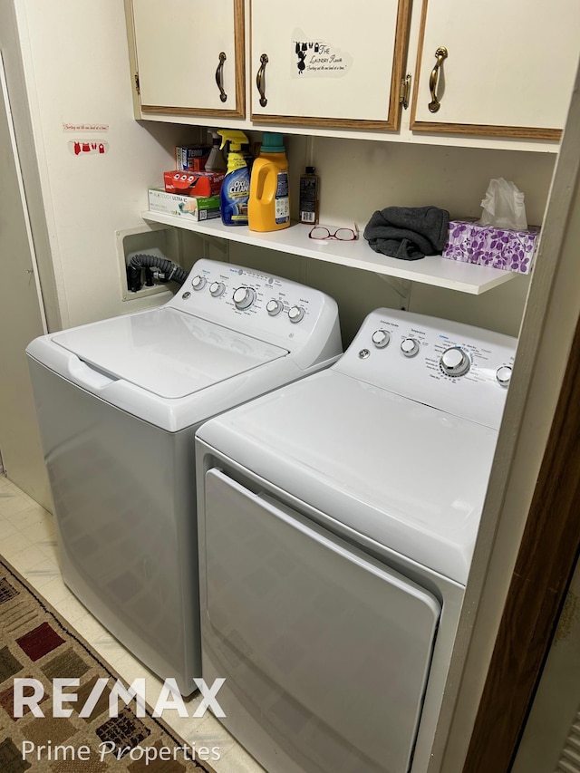 washroom with cabinets, separate washer and dryer, and light tile patterned floors