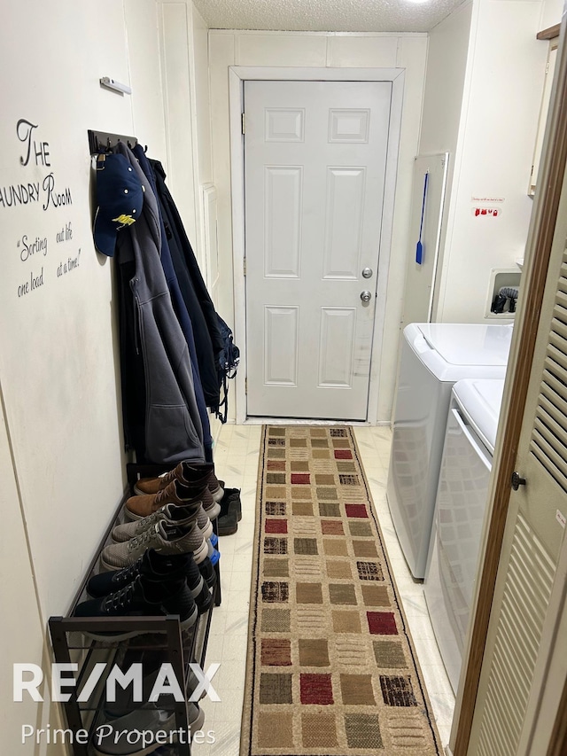 laundry room featuring washer and clothes dryer and a textured ceiling