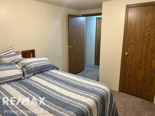 carpeted bedroom featuring a textured ceiling