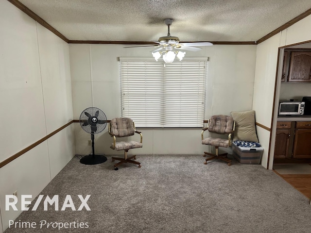 sitting room with light colored carpet, ornamental molding, and a textured ceiling