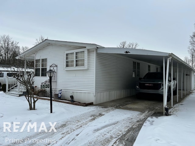 view of snow covered exterior with a carport