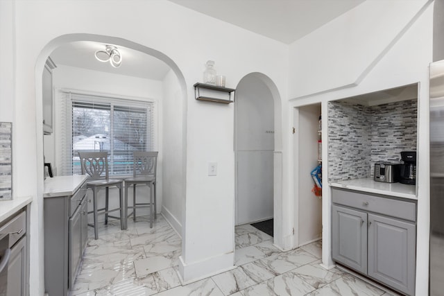 kitchen featuring backsplash and gray cabinets