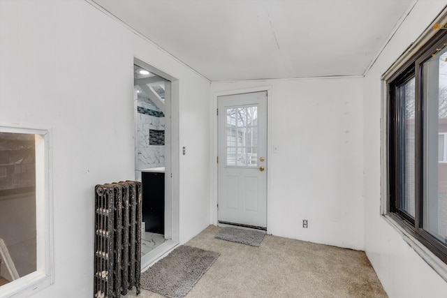 interior space with light carpet and radiator heating unit