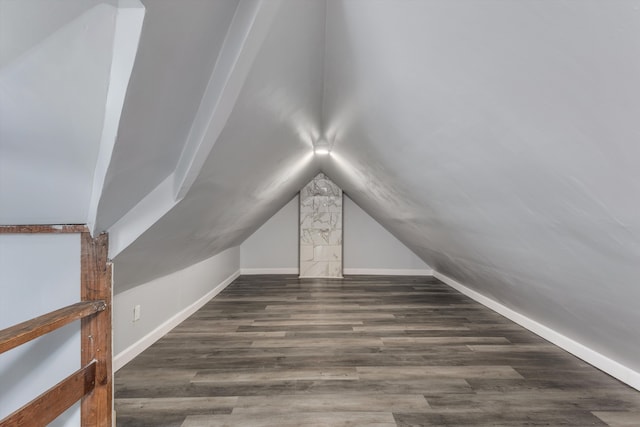 additional living space with dark wood-type flooring and lofted ceiling